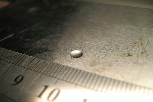 Impronta lasciata dal penetratore sferico su una lastra di campione a seguito della prova di durezza Brinell. Credits: Wikimedia Commons.
