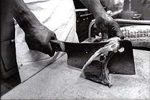 A cleaver in use, being used to cut pork chops from a loin of pork Cleaver (PSF).jpg