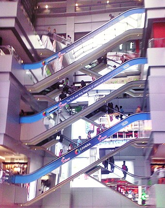 Crisscross layout of escalators at Mahboonkrong Center, widely known as the MBK Center, in Bangkok. Such layouts are used to minimize structural space requirements by "stacking" escalators that go in one direction.