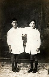 Fotografía de dos niños argentinos con el característico guardapolvo blanco de la Escuela Pública.