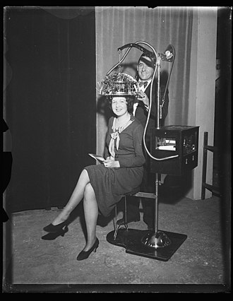 A man fitting a psychograph on a woman's head. Identified! (Woman seated with a psychograph, a phrenology machine, on her head) (LOC) (21702262098).jpg