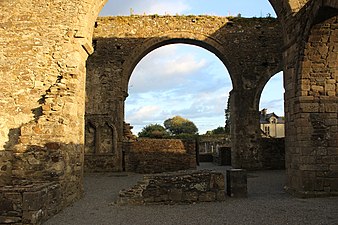 Halvsirkelformede buer i en delvis ødelagt kirke.