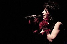 Photo of a woman singing in darkness