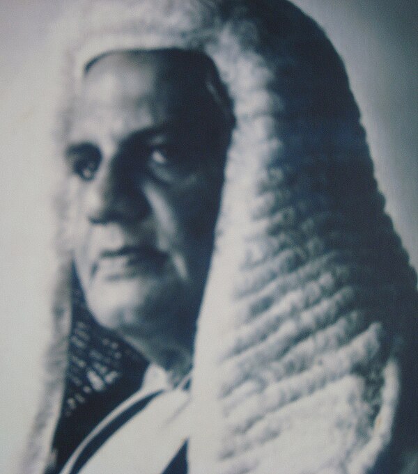 Justice Manicavasagar in long wig and court dress