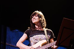 Ana Fernández-Villaverde at a live concert playing electric bass.