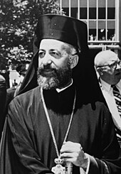 Photo en noir et blanc d'un pope orthodoxe portant barbe et robe noires.