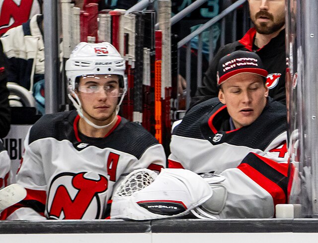 Hughes (left) on the Devils bench during a December 2023 game