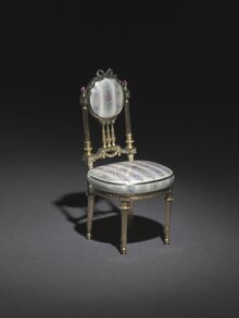 Miniature chair; by Peter Carl Faberge; made between 1896 and 1906; Gold, silver gilt, enamel over engine turned ground simulating brocaded textile, rubies and diamonds; overall: 10.5 x 5.3 x 4.8 cm; Cleveland Museum of Art (USA) Peter Carl Faberge - Miniature Chair - 1966.454 - Cleveland Museum of Art.tif