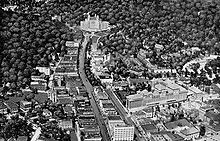Aerial view of Hot Springs after 1925 along Central Avenue. The base of Hot Springs Mountain is in top right, behind Bathhouse Row. Part of West Mountain is on the left. The southwest edge of North Mountain is behind the Arlington Hotel at top. Picturesque Hot Springs Central Avenue 1924.jpg