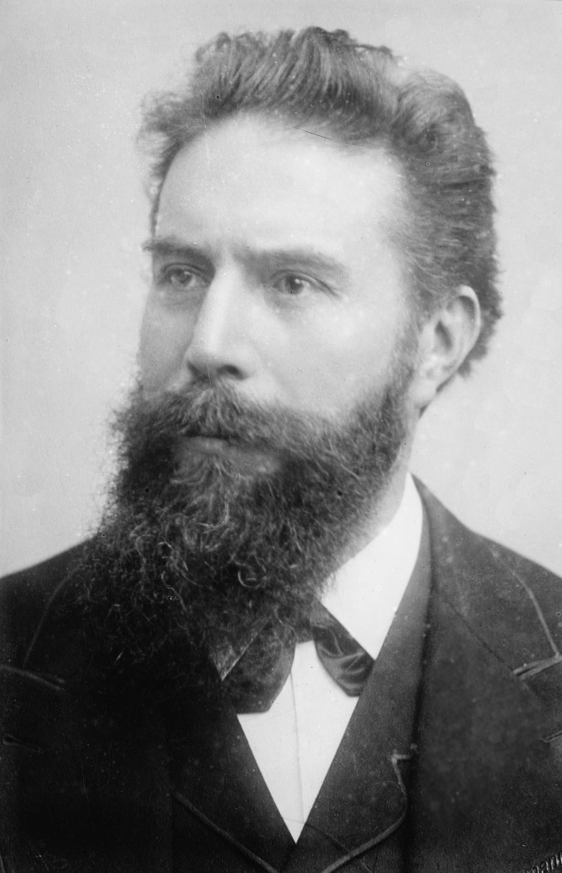 A black and white photo of a bearded man in his fifties sitting in a chair.