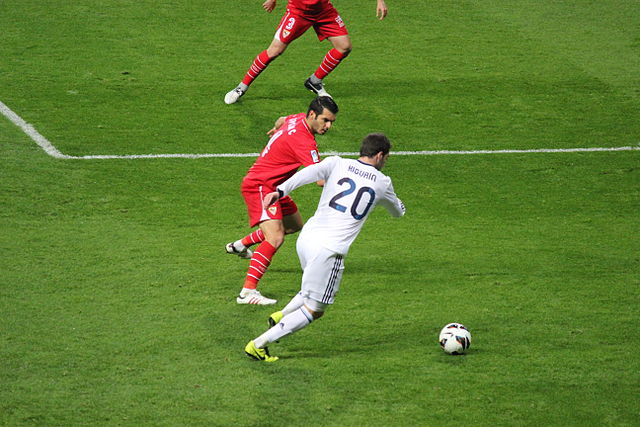 Higuaín attempting to dribble past Emir Spahić of Sevilla in February 2013