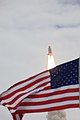 STS-135 passing National flag in foreground.jpg