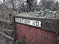 Thumbnail for File:Sign for Station Road, Hugglescote with the former station under the bridge in an overgrown cutting.jpg