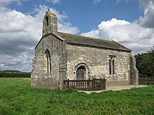 Sebuah kapel kecil dilihat dari selatan, dengan bellcote di kiri, satu pintu dan satu jendela