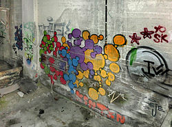 The graffiti on the wall to the right.