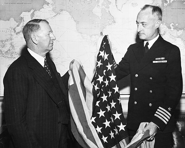 Secretary of the Navy Frank Knox is presented with the flag that flew over Kwajalein by Captain James H. Doyle.