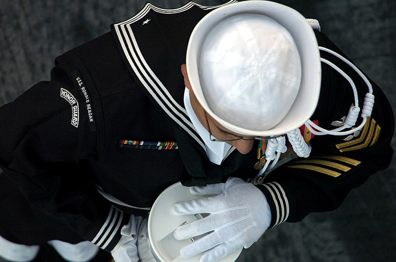 File:US Navy 061027-N-0555B-198 A member of USS Ronald Reagan (CVN 76) Honor Guard holds the remains of a World War II veteran to be committed to the ocean during a burial at sea.jpg