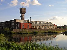 DRU Cultuurfabriek in Ulft mit dem charakteristischen ehemaligen Wasserturm der Fabrik über heutigen Wohngebäuden. Die „Kulturfabrik“ liegt etwas weiter stromaufwärts.