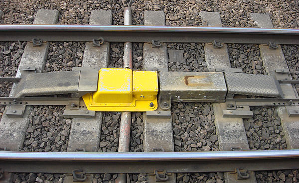 Automatic warning system magnet located between the rails