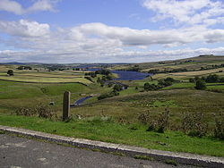Вид на широкую долину с озером посередине.