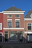 Pand voorheen winkelwoonhuis, uit de tweede helft van de 19e eeuw, in een sobere traditioneel-classicistische bouwtrant.