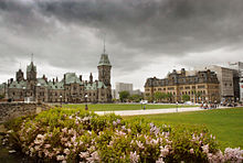 After Confederation, the federal government constructed a series of monumental structures, including the Victorian High Gothic Parliament buildings (left), and the Second Empire-styled Langevin Block (right). East Block and Langevin Block.jpg