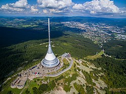 Vysílač a hotel Ještěd a v pozadí krajské město Liberec
