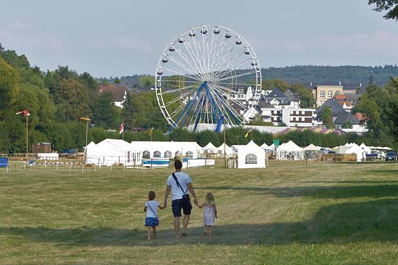 Father and daughters going to the Laurentiusmarkt (fair) in Usingen, Taunus, Germany