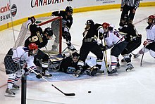 Fotografia di un'azione di gioco di hockey su ghiaccio.