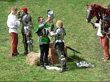 A squire helping his knight, in a historical reenactment in 2009 Malbork rekonstrukcja 2009 (8).JPG