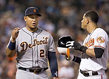 Deux joueurs de baseball discutent sur le terrain.