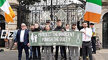 Members of the National Party holding up a banner and signs containing noose imagery during a protest directed at Roderic O'Gorman in Dublin in July 2020 National Party members hold up noose imagery.jpg