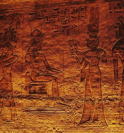 Nefertari offering sistrums to seated goddess Hathor. Frieze inside the Small Temple.
