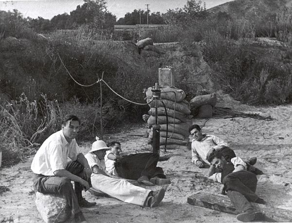 Seated left to right: Rudolph Schott, Apollo Milton Olin Smith, Frank Malina (white shirt, dark pants), Ed Forman and Jack Parsons (right, foreground)