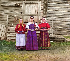 Jeunes paysannes russes devant une maison traditionnelle en bois (entre 1909 et 1915), photo de Sergei Mikhailovich Prokudin-Gorskii. (définition réelle 3 320 × 2 873*)