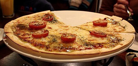 A Southern Italian-style pizza: thin crust, large slices of tomato, less cheese than most American styles, and drizzled with oil and herbs