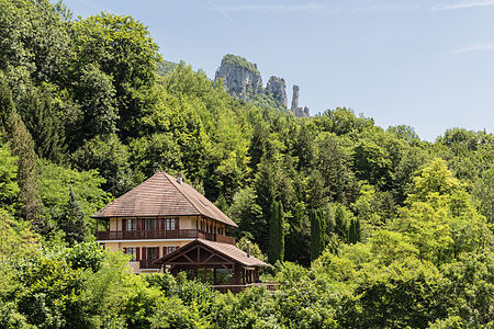 Hotel Restaurant Aux Gorges du Chéran and west view of the Saint-Jacques Towers in the background, from the Abyss Bridge in Cusy, France.