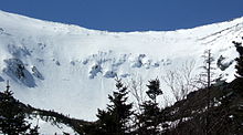 Cuenco del Tuckerman Ravine (Barranco Tuckerman), mostrando esquiadores por encima del pico