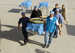 UN members carrying remains of bombing victims from UNOHCI onto an aircraft at Baghdad International Airport..jpg