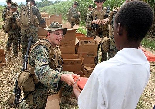 US Navy 100126-M-8605C-002 A Marine assigned to the Battalion Landing Team, 3rd Battalion, 2nd Marine regiment, distributes humanitarian rations at an aid station near a landing zone in Leogane, Haiti