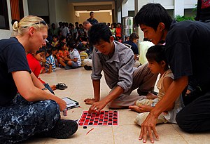 US Navy 100623-N-4044H-047 Religious Programs Specialist 1st Class Jennifer Snow, assigned to the Military Sealift Command hospital ship USNS Mercy (T-AH 19), plays checkers with church members during a community service event.jpg