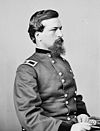 Man sitting with beard looking right in military uniform