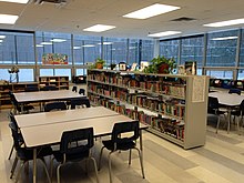 Una biblioteca escolar en Quebec.  Mesas de trabajo y estanterías.