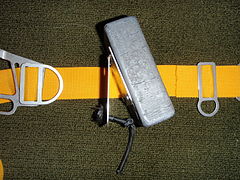 Clip-on monolithic block type main dive weight showing the hinged grip plate and shock cord retainer