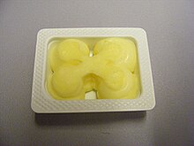 A single-serving packet of butter Butter single portion in container.JPG