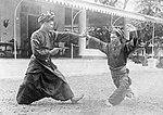 COLLECTIE TROPENMUSEUM Schermdansers en Fort de Kock aan de Sumatraanse westkust TMnr 10004584.jpg