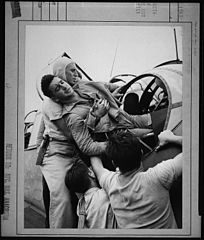 Crewmen lifting Kenneth Bratton (AOM) out of turret of TBF on the USS Saratoga (CVA-3) after raid on Rabaul. - NARA - 520757.jpg