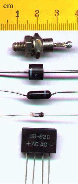 Various semiconductor diodes. Bottom: A bridge rectifier. In most diodes, a white or black painted band identifies the cathode into which electrons wi