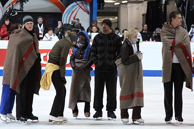 Skaters react to the rink's cold temperatures during the practice for the exhibition gala.