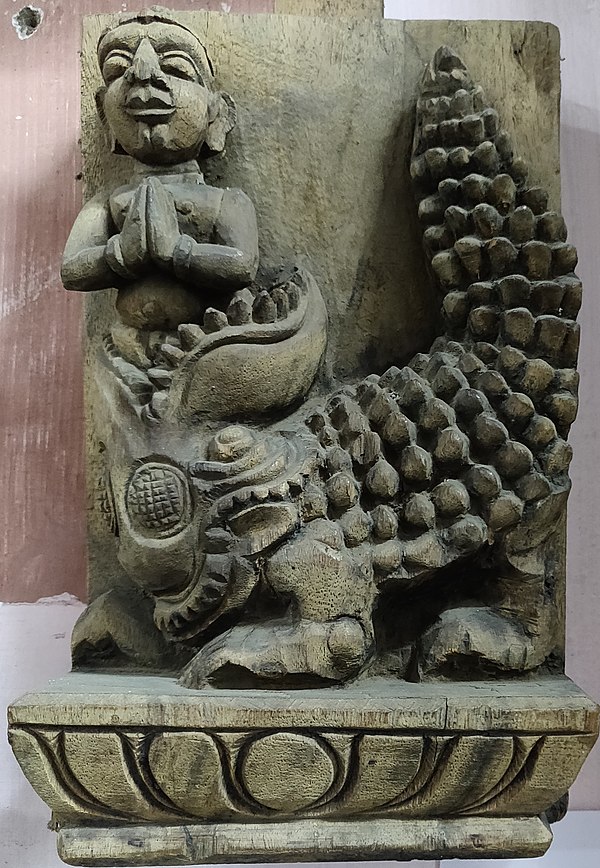 Scene of boy coming back to life from crocodile after Sundarar sings hymn—Wooden sculpture.